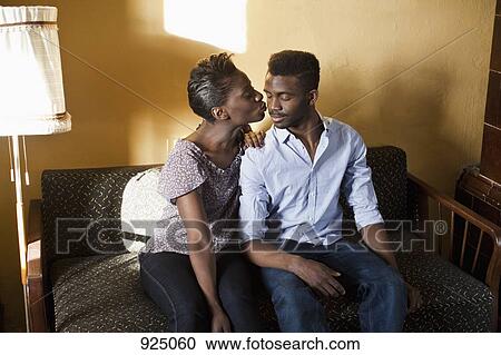 A young affectionate couple on a couch View Large Photo Image Stock Image - A young affectionate couple on a couch. Fotosearch