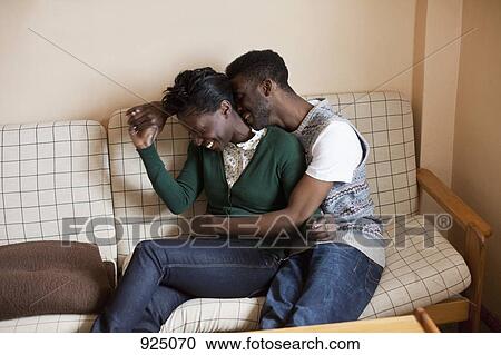 A young affectionate couple relaxing on a couch View Large Photo Image Stock Image - A young affectionate couple relaxing on a couch. Fotosearch