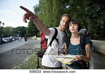 Stock Image - A young backpacker couple looking at a city map. Fotosearch