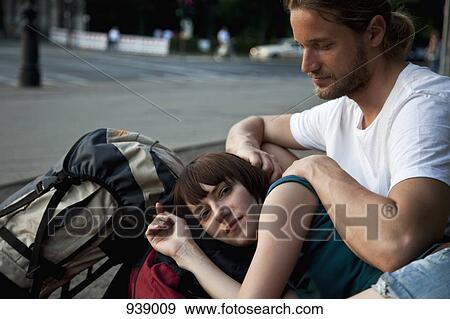 Stock Photo - A young backpacker couple resting. Fotosearch