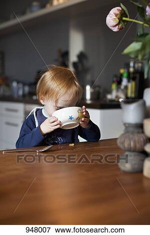 A young boy eating from a bowl View Large Photo Image Stock Photo - A young boy eating from a bowl. Fotosearch
