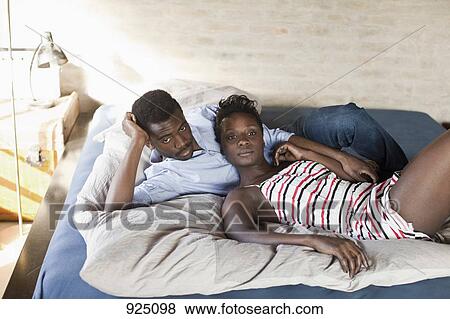 A young couple relaxing in bed View Large Photo Image Stock Photo - A young couple relaxing in bed. Fotosearch