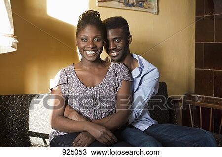 Stock Image - A young couple relaxing on a couch, portrait. Fotosearch
