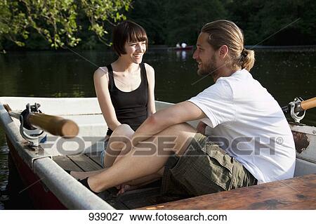 Stock Photo - A young couple talking in a rowboat. Fotosearch
