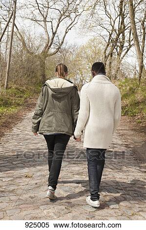 A young couple walking down a rural cobblestone road View Large Photo Image Stock Photography - A young couple walking down a rural cobblestone road. Fotosearch