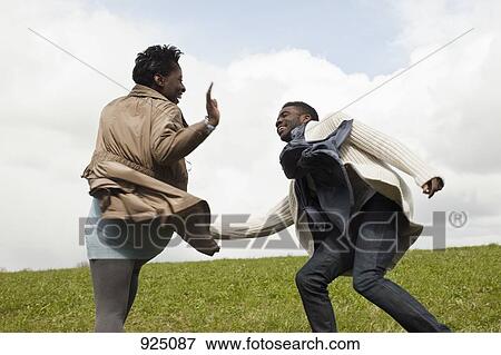 A young man chasing his girlfriend down a hill View Large Photo Image Stock Photo - A young man chasing his girlfriend down a hill. Fotosearch