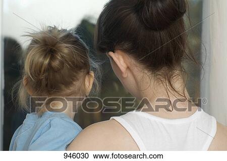 Stock Image - A young woman holding her young daughter. Fotosearch