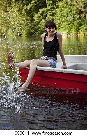 A young woman in a rowboat splashing water with her foot View Large Photo Image Stock Image - A young woman in a rowboat splashing water with her foot. Fotosearch