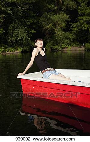 A young woman sunbathing in a rowboat View Large Photo Image Stock Image - A young woman sunbathing in a rowboat. Fotosearch