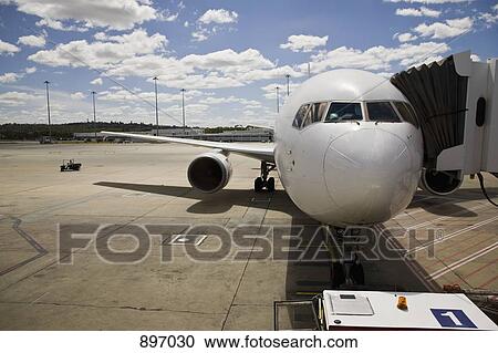 An airplane connected to a passenger boarding bridge View Large Photo Image Stock Image - An airplane connected to a passenger boarding bridge. Fotosearch