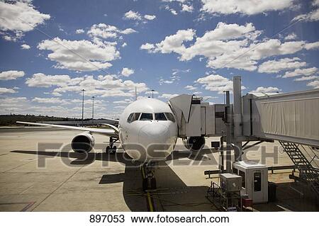 An airplane connected to a passenger boarding bridge View Large Photo Image Stock Image - An airplane connected to a passenger boarding bridge. Fotosearch