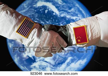 An American astronaut shaking hands with a Chinese astronaut View Large Photo Image Stock Photograph - An American astronaut shaking hands with a Chinese astronaut. Fotosearch