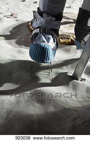 Stock Photo - An astronaut climbing the ladder of a lunar lander on the moon. Fotosearch