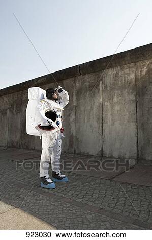 An astronaut on a city sidewalk looking up into the sky View Large Photo Image Stock Image - An astronaut on a city sidewalk looking up into the sky. Fotosearch
