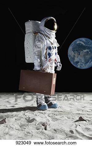 An astronaut on the moon carrying a suitcase View Large Photo Image Stock Photo - An astronaut on the moon carrying a suitcase. Fotosearch