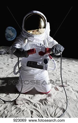 Stock Photo - An astronaut on the moon connecting two cables. Fotosearch