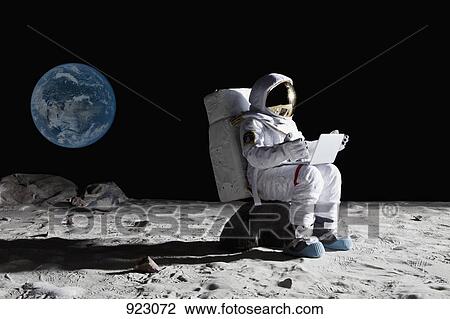 An astronaut on the moon sitting on a rock using a laptop View Large Photo Image Stock Image - An astronaut on the moon sitting on a rock using a laptop. Fotosearch