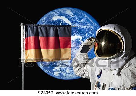Stock Photo - An astronaut saluting an German flag with the earth in the background. Fotosearch