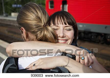 An happy woman hugs her boyfriend on a train platform View Large Photo Image Stock Image - An happy woman hugs her boyfriend on a train platform. Fotosearch
