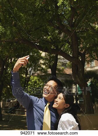 An romantic, business couple taking a photograph of themselves View Large Photo Image Stock Image - An romantic, business couple taking a photograph of themselves. Fotosearch
