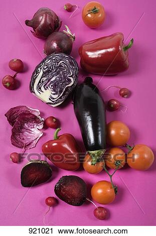 Stock Image - Arrangement of red and purple vegetables on a pink background. Fotosearch