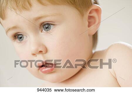 Close-up of a young boy looking away View Large Photo Image Stock Photography - Close-up of a young boy looking away. Fotosearch