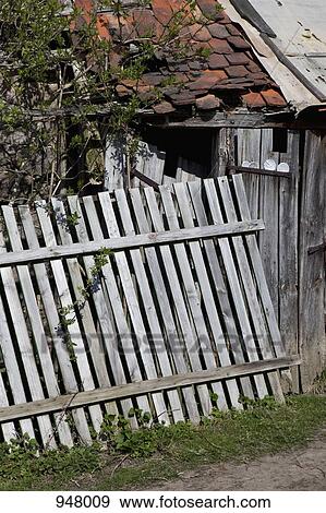 Detail of a collapsing fence in front of a rundown house View Large Photo Image Stock Photo - Detail of a collapsing fence in front of a rundown house. Fotosearch