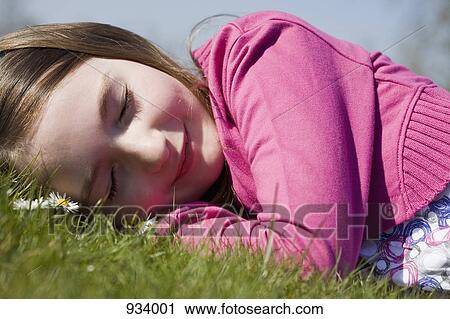Detail of a girl lying down on grass View Large Photo Image Stock Image - Detail of a girl lying down on grass. Fotosearch