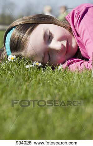 Stock Photo - Detail of a girl lying down on grass. Fotosearch
