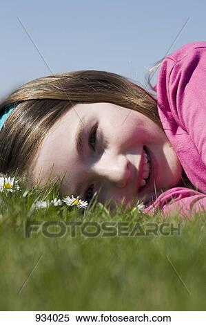 Detail of a girl lying down on grass View Large Photo Image Stock Photography - Detail of a girl lying down on grass. Fotosearch