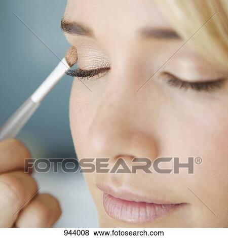 Detail of a young woman applying eye shadow View Large Photo Image Stock Photo - Detail of a young woman applying eye shadow. Fotosearch