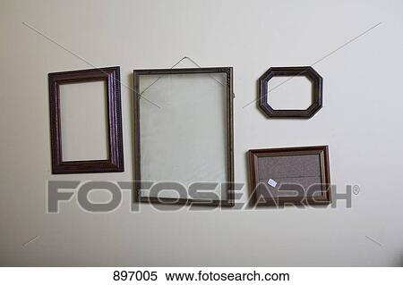 Empty picture frames hanging on a wall View Large Photo Image Stock Photography - Empty picture frames hanging on a wall. Fotosearch