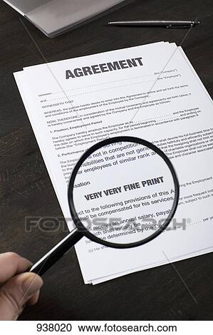 Stock Image - Examining the fine print of an employment agreement with a magnifying glass. Fotosearch
