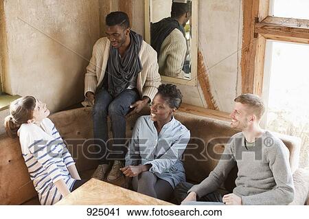 Four friends relaxing at a table View Large Photo Image Stock Image - Four friends relaxing at a table. Fotosearch