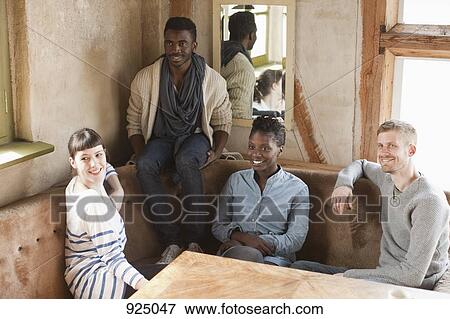 Four friends relaxing at a table View Large Photo Image Stock Photo - Four friends relaxing at a table. Fotosearch