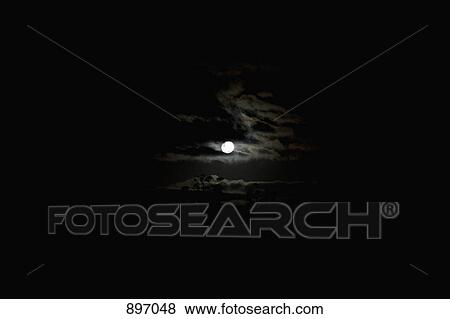 Stock Photo - Full moon and clouds in the sky. Fotosearch