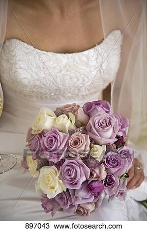 Midsection of a bride holding a bouquet of flowers View Large Photo Image Stock Image - Midsection of a bride holding a bouquet of flowers. Fotosearch