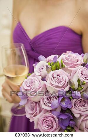 Midsection of a bridesmaid holding a bouquet of flowers and a glass of wine View Large Photo Image Stock Image - Midsection of a bridesmaid holding a bouquet of flowers and a glass of wine. Fotosearch