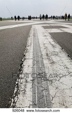 Stock Photo - People walking on an airport tarmac. Fotosearch