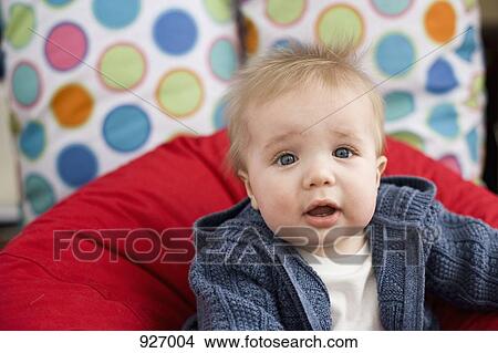 Picture - Portrait of a baby leaning on a pillow. Fotosearch
