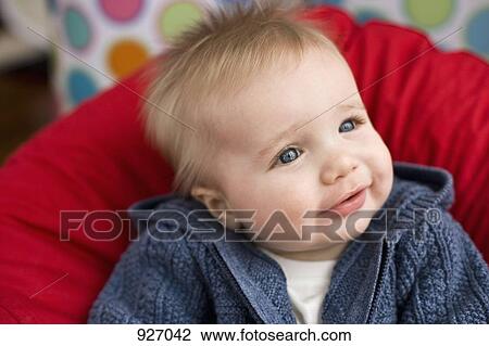 Stock Image - Portrait of a baby leaning on a pillow. Fotosearch