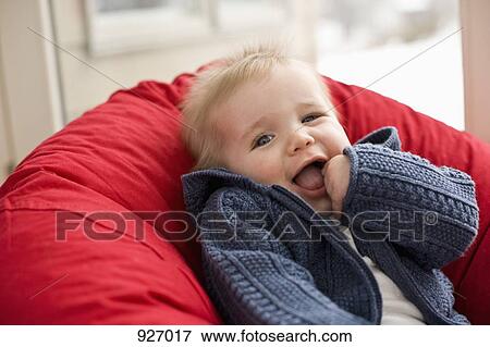Stock Photo - Portrait of a baby leaning on a pillow. Fotosearch