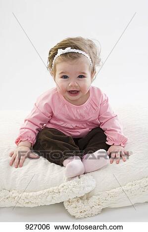 Portrait of a baby sitting on two pillows View Large Photo Image Stock Photograph - Portrait of a baby sitting on two pillows. Fotosearch