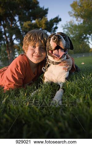 Portrait of a boy lying on grass with a dog View Large Photo Image Stock Image - Portrait of a boy lying on grass with a dog. Fotosearch