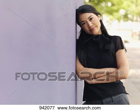 Portrait of a businesswoman leaning against a wall View Large Photo Image Stock Photo - Portrait of a businesswoman leaning against a wall. Fotosearch