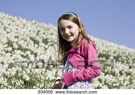 Portrait of a girl standing in a field of flowers View Large Photo Image Stock Photo - Portrait of a girl standing in a field of flowers. Fotosearch
