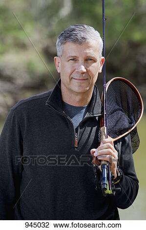 Portrait of a man holding fishing equipment View Large Photo Image Stock Image - Portrait of a man holding fishing equipment. Fotosearch