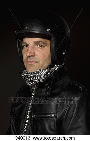 Stock Image - Portrait of a man wearing a helmet and leather jacket. Fotosearch
