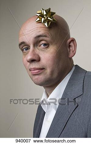 Portrait of a man with a gift bow on his head View Large Photo Image Stock Photo - Portrait of a man with a gift bow on his head. Fotosearch