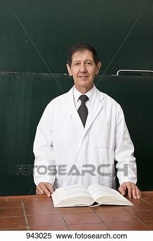 Portrait of a science teacher with an open textbook in his classroom View Large Photo Image Stock Photography - Portrait of a science teacher with an open textbook in his classroom. Fotosearch